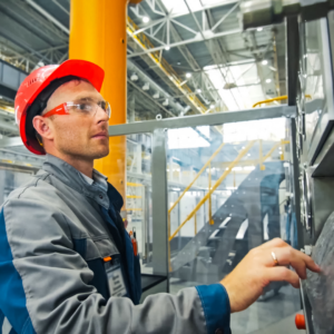 Parcours Formation | CRCA | homme dans une usine qui utilise le panneau de contrôle des machines