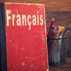 Parcours Formation | Article | Nouveau travailleur allophone qui a besoin d'apprendre le français et les expressions québécoises | Un livre de français avec des crayons